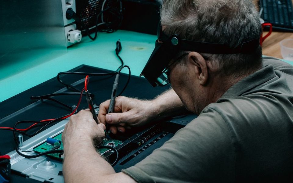 Technician soldering a circuit board in the workshop