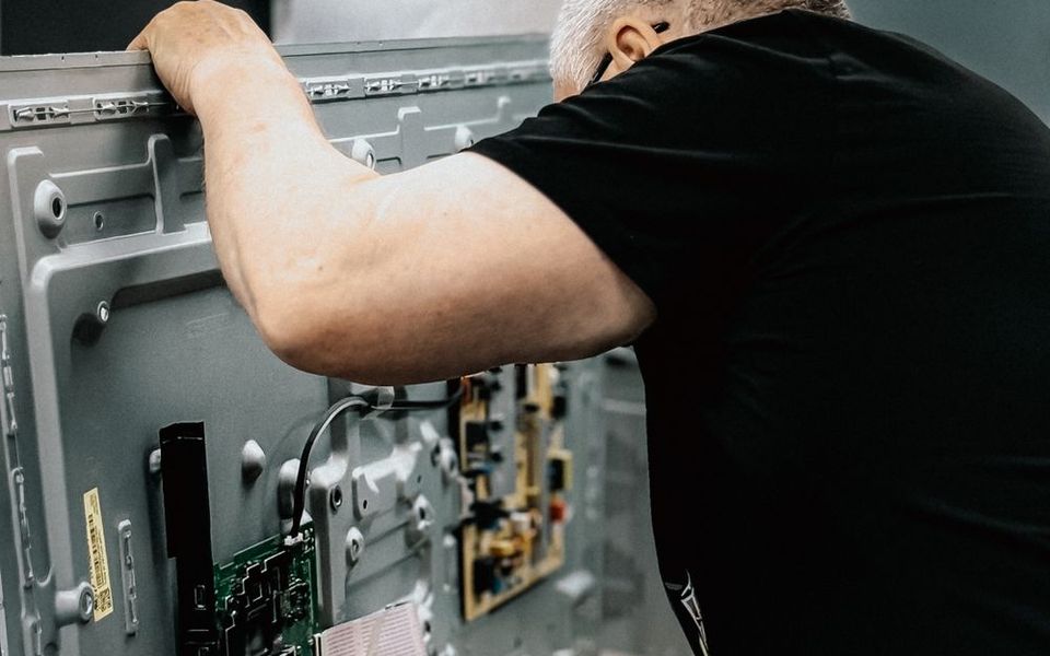 Technician repairing a television circuit board